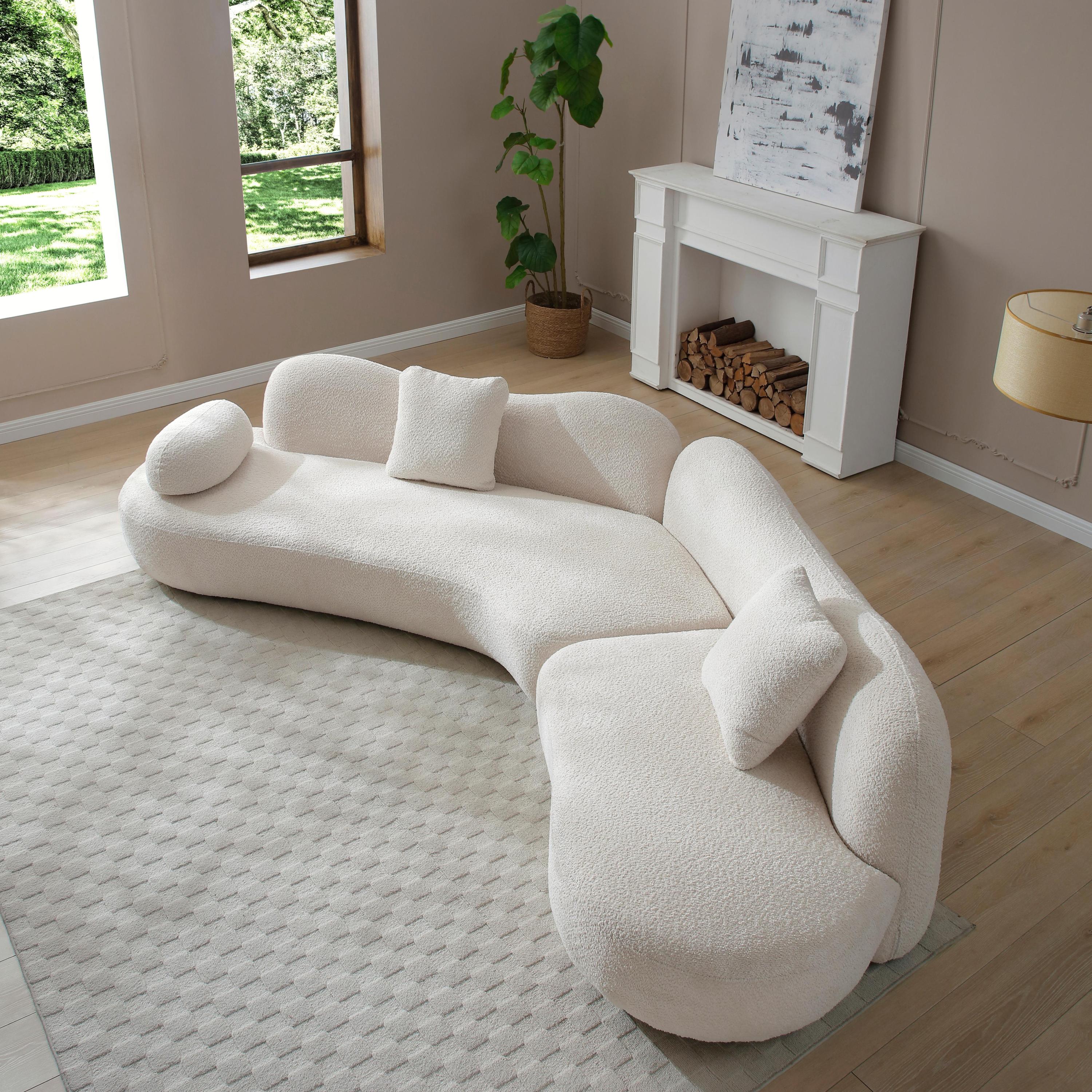 Top angled view of curved sectional sofa in white boucle, showcasing its butterfly backrest and plush cushions in a bright room.