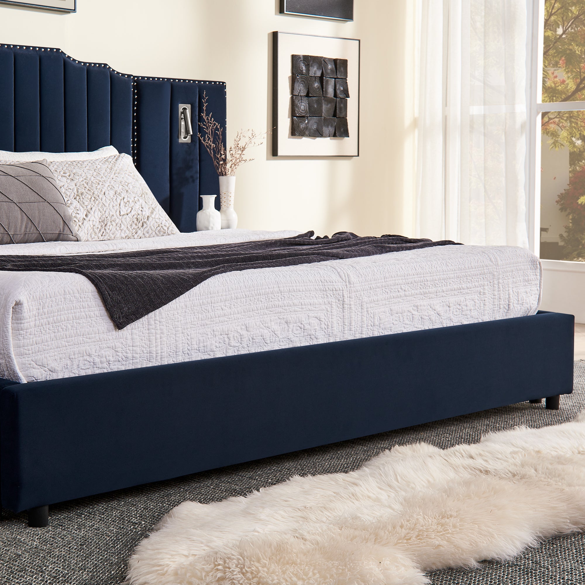 Side view of queen velvet bed frame with under-bed storage and soft white bedding in a cozy, modern bedroom.