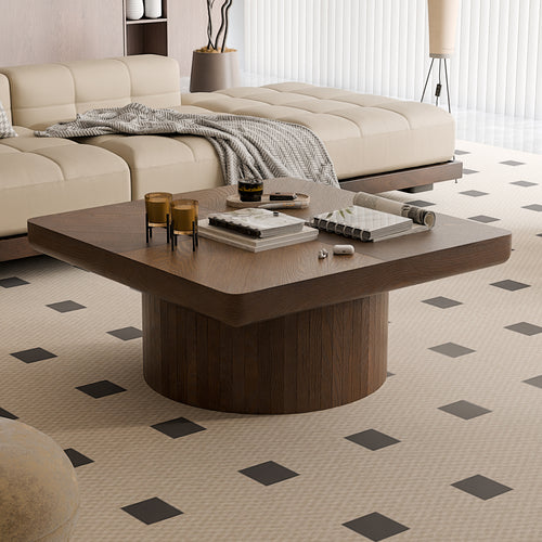Walnut square coffee table with parquet pattern top and cylindrical base in a modern living room with beige sectional sofa.