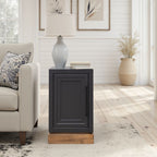 Nora Chairside Table - Black Whiskey Finish next to a beige couch in a bright room, showcasing its compact and stylish design.