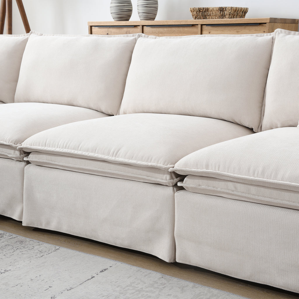 Detailed view of modular sectional sofa cushions, emphasizing soft beige upholstery and thick padding for luxurious living room seating.