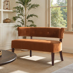 Mid-century Burnt Orange Velvet Bench placed by a sunlit window, showcasing its curved back and dark wood legs.
