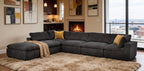 Dark gray modular sectional sofa with plush upholstery, yellow throw pillows, and tan blanket on a shaggy area rug.