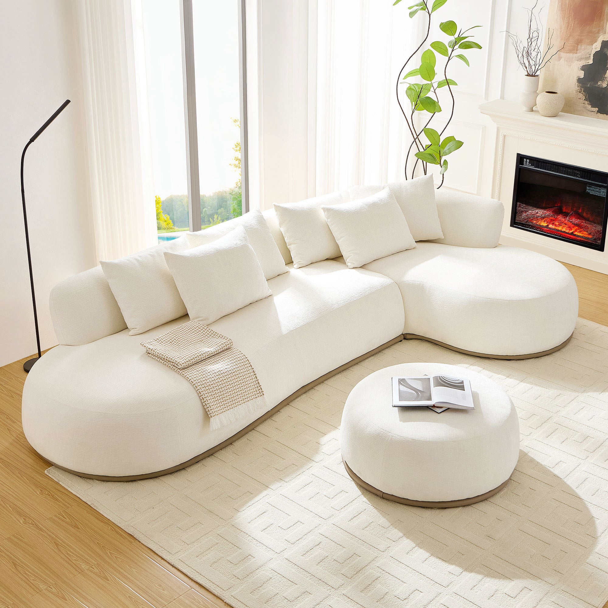Modern beige L-shape sectional sofa with ottoman placed on a patterned rug, ideal for spacious living rooms with natural light and minimalist design.