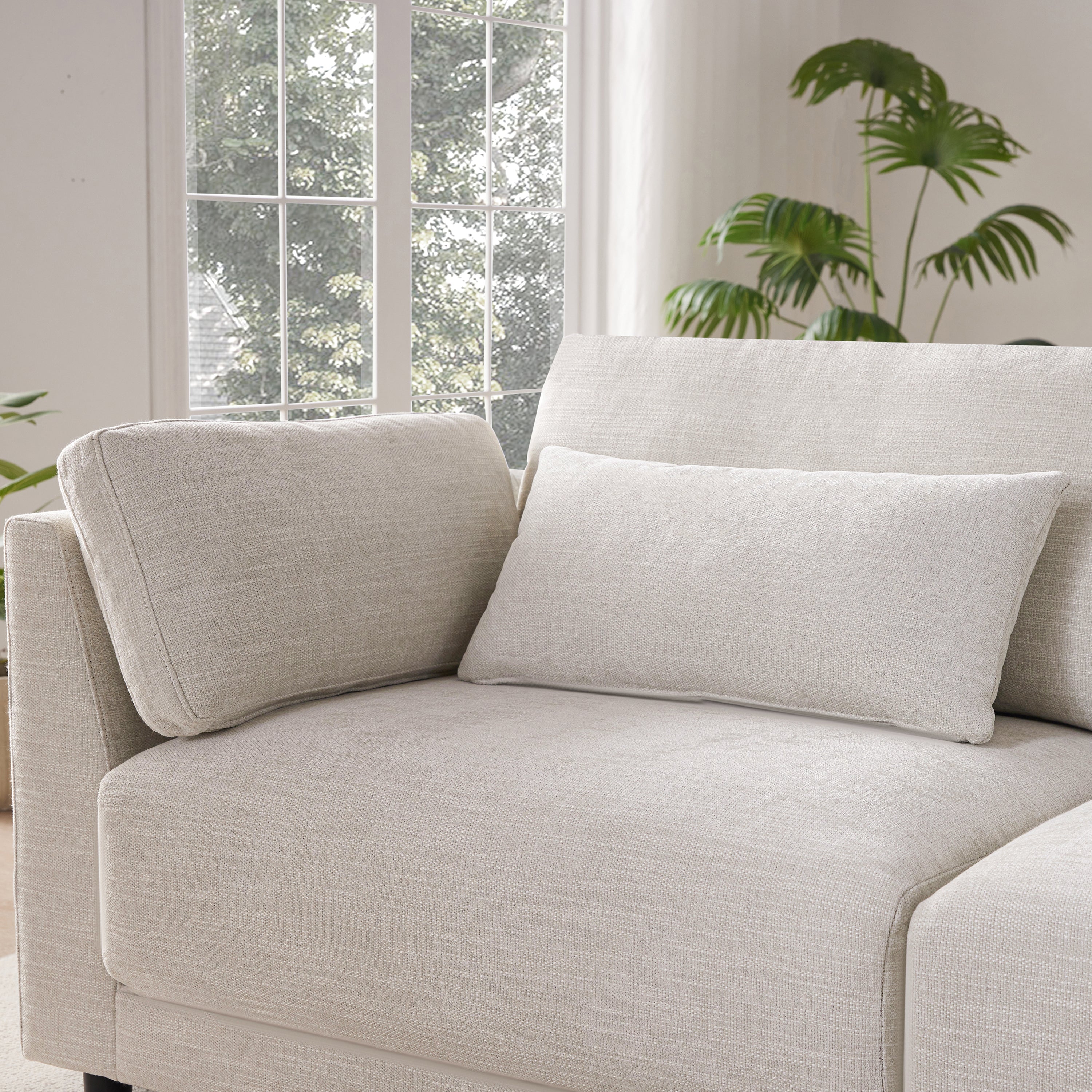 Close-up of L-Shaped sectional sofa’s corner seat with plush cushions and lumbar pillow, offering ultimate comfort and support.