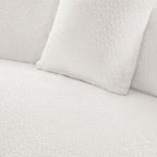 Close-up of white bouclé fabric and cushion texture on modern curved sofa set, emphasizing soft, luxurious upholstery.