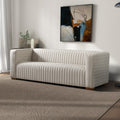 Elara cream velvet sofa featuring vertical channel tufting and a modern, minimalist silhouette on a textured area rug.