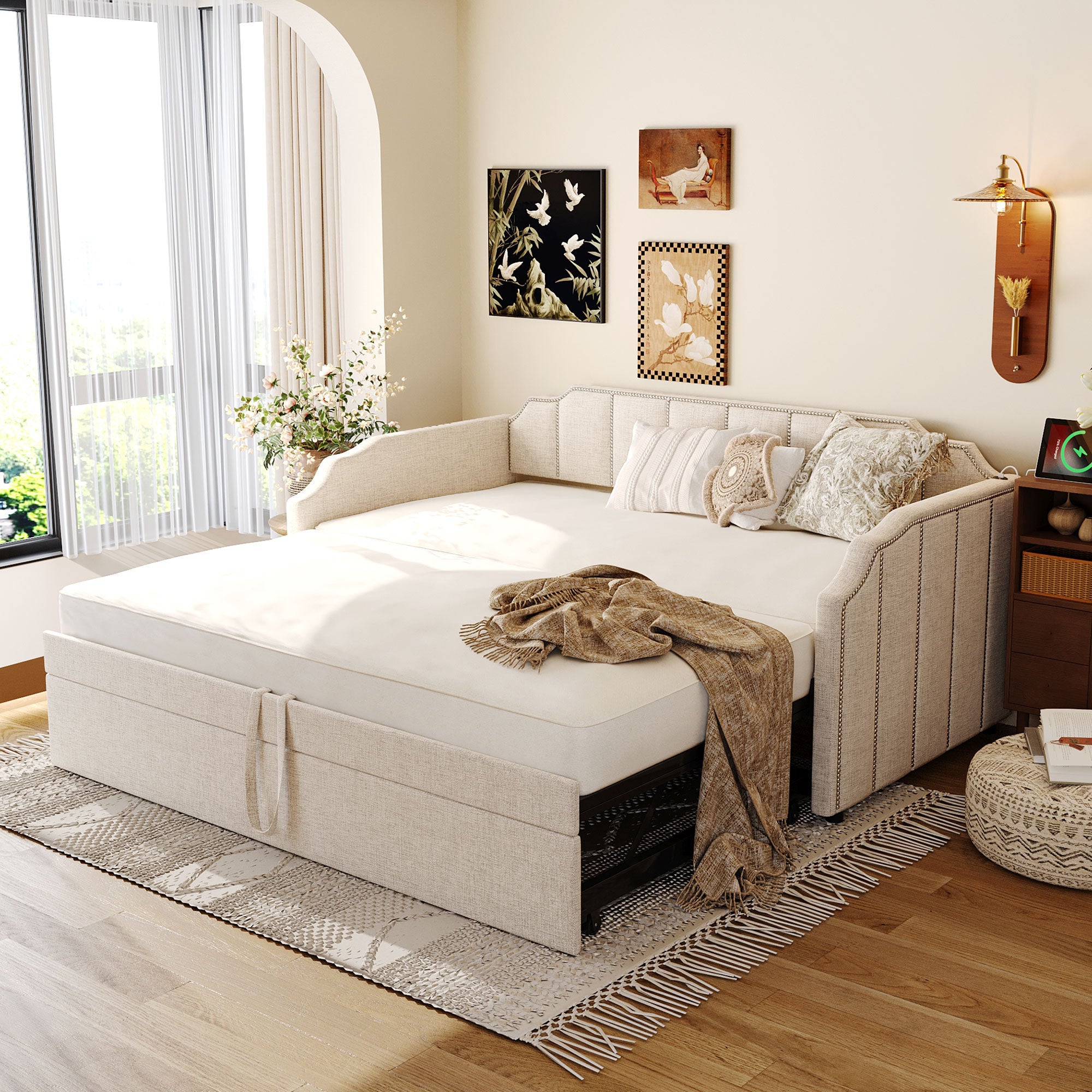 Beige upholstered twin daybed with a pop-up trundle, nailhead trim, and integrated USB ports in a cozy bedroom setting.