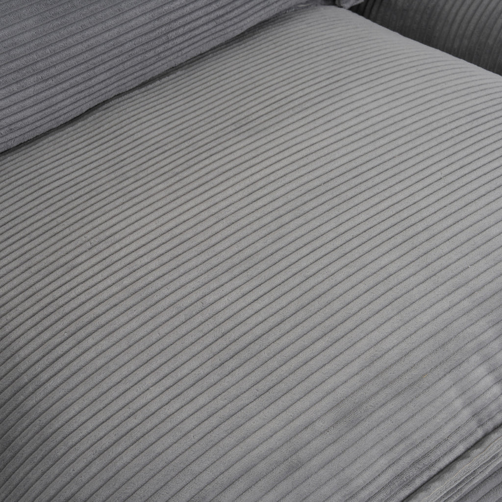 Detailed view of seat cushion surface on dark grey modular sofa, showcasing soft corduroy texture and plush upholstery.
