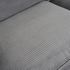 Detailed view of seat cushion surface on dark grey modular sofa, showcasing soft corduroy texture and plush upholstery.