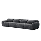 Angled side view of 149'' modular plush sofa in dark grey, showcasing its rounded edges and deep cushioned seats.