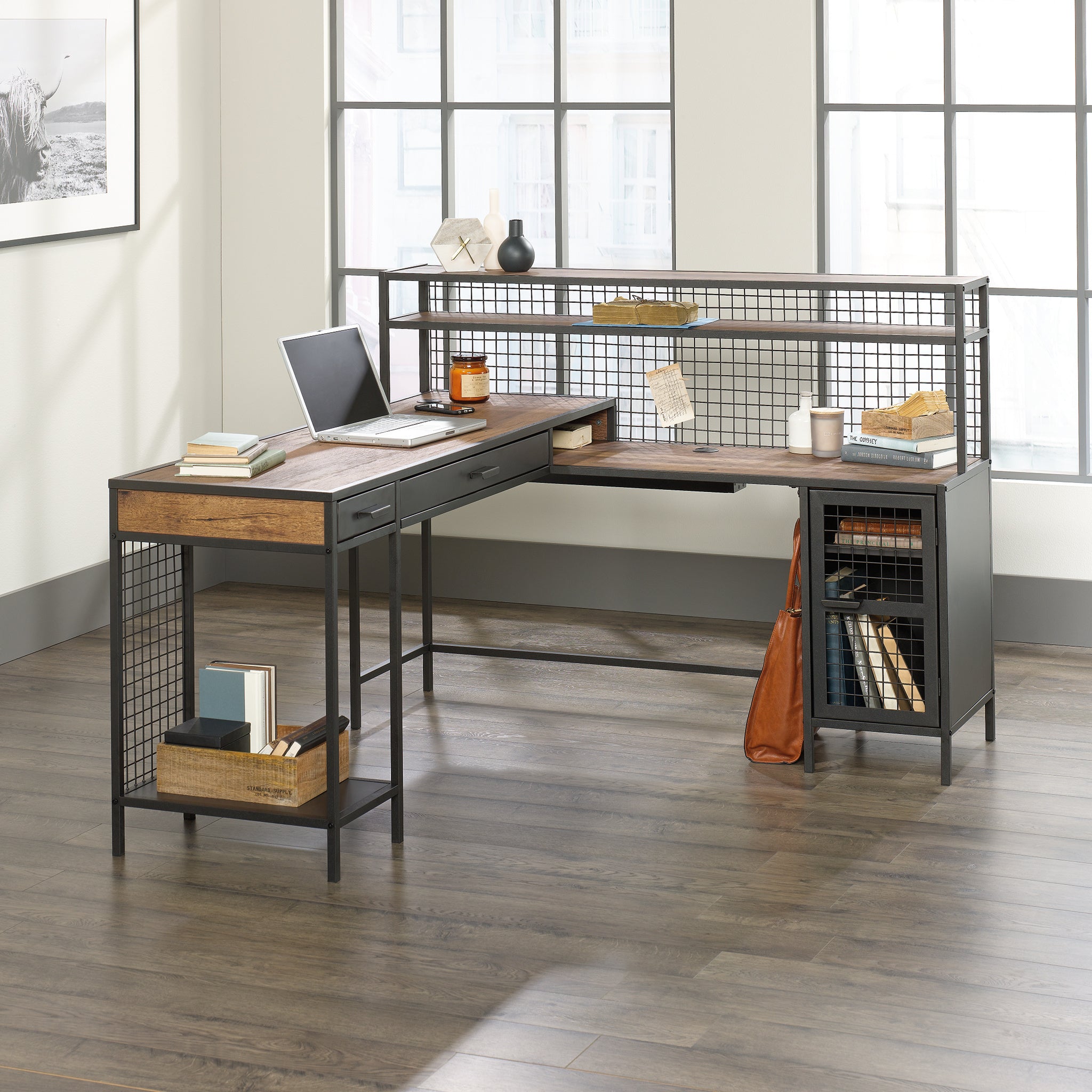 L-shaped computer desk in brown finish with industrial metal frame, open shelving, drawers, and cable management for modern office setup.
