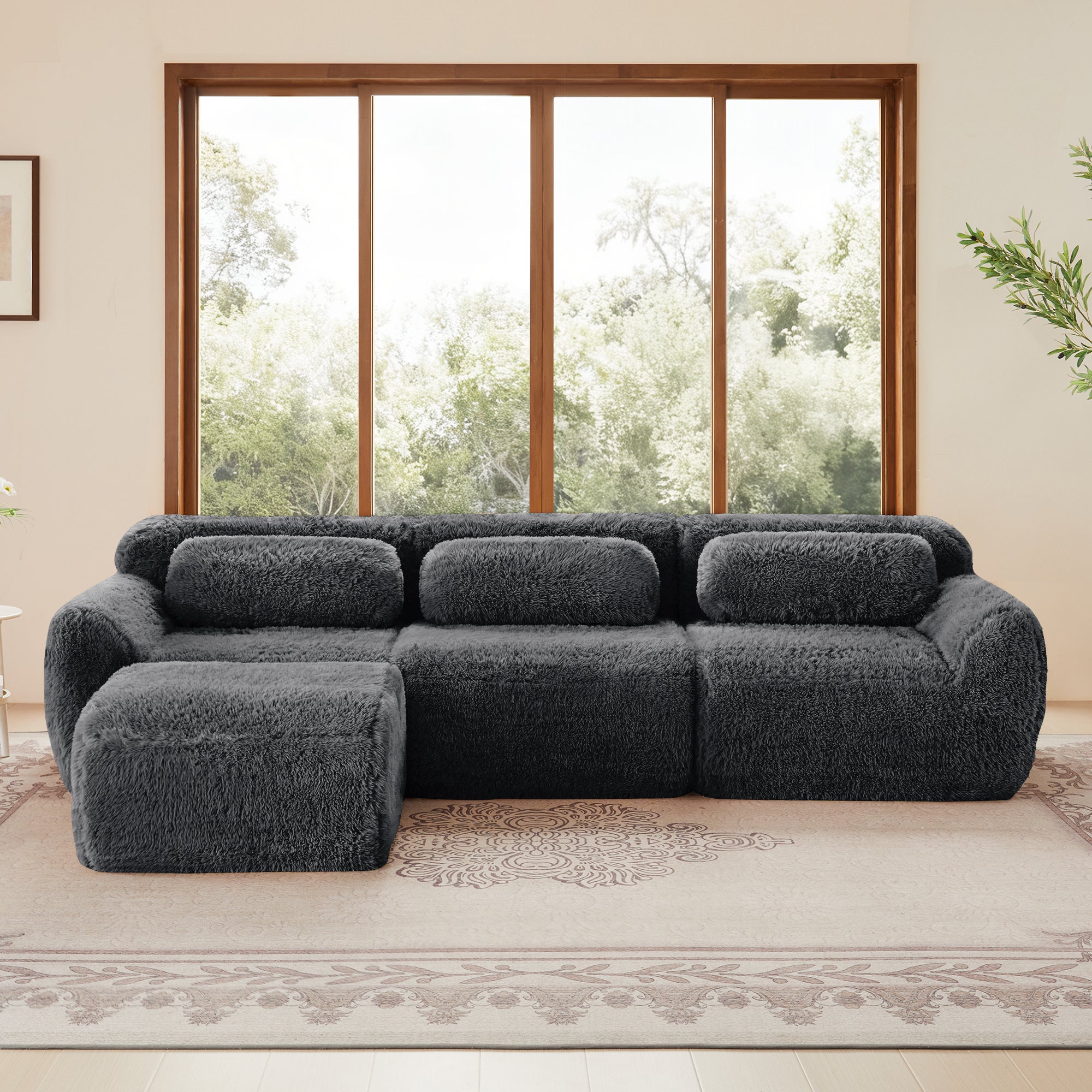 Dark Grey Plush Modular L-Shaped Sofa with Ottoman shown front-facing, highlighting its ergonomic backrest and deep seating on a patterned rug.
