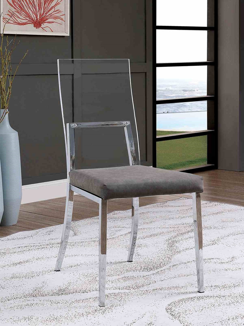 Minimalist style dining chair with chrome legs, acrylic backrest, and gray cushioned seat in a modern room setting.