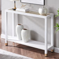 Modern 2-tier white console table with a glass top, gold accents, and a lower shelf, staged with home decor.
