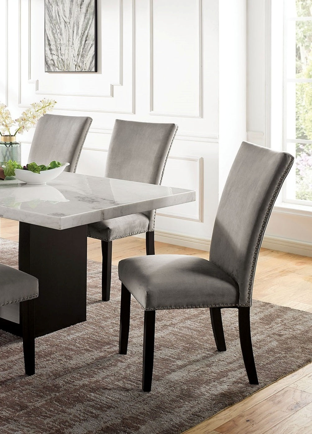 Close-up of grey upholstered chairs and marble top of 7pc marble dining table set. Stylish seating for contemporary dining rooms.