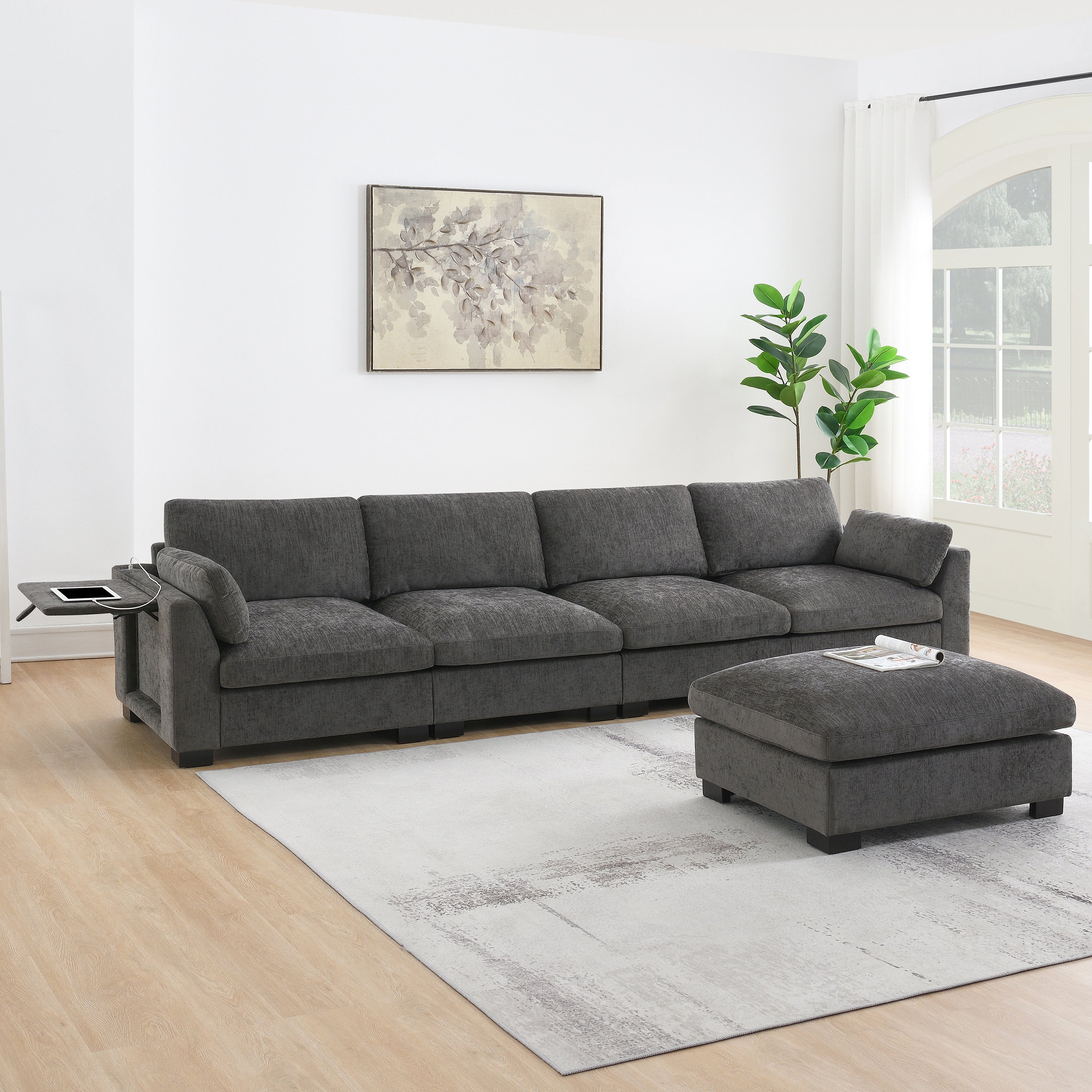 Charcoal gray chenille modular sectional sofa with folding tray, charging port, and a matching ottoman.