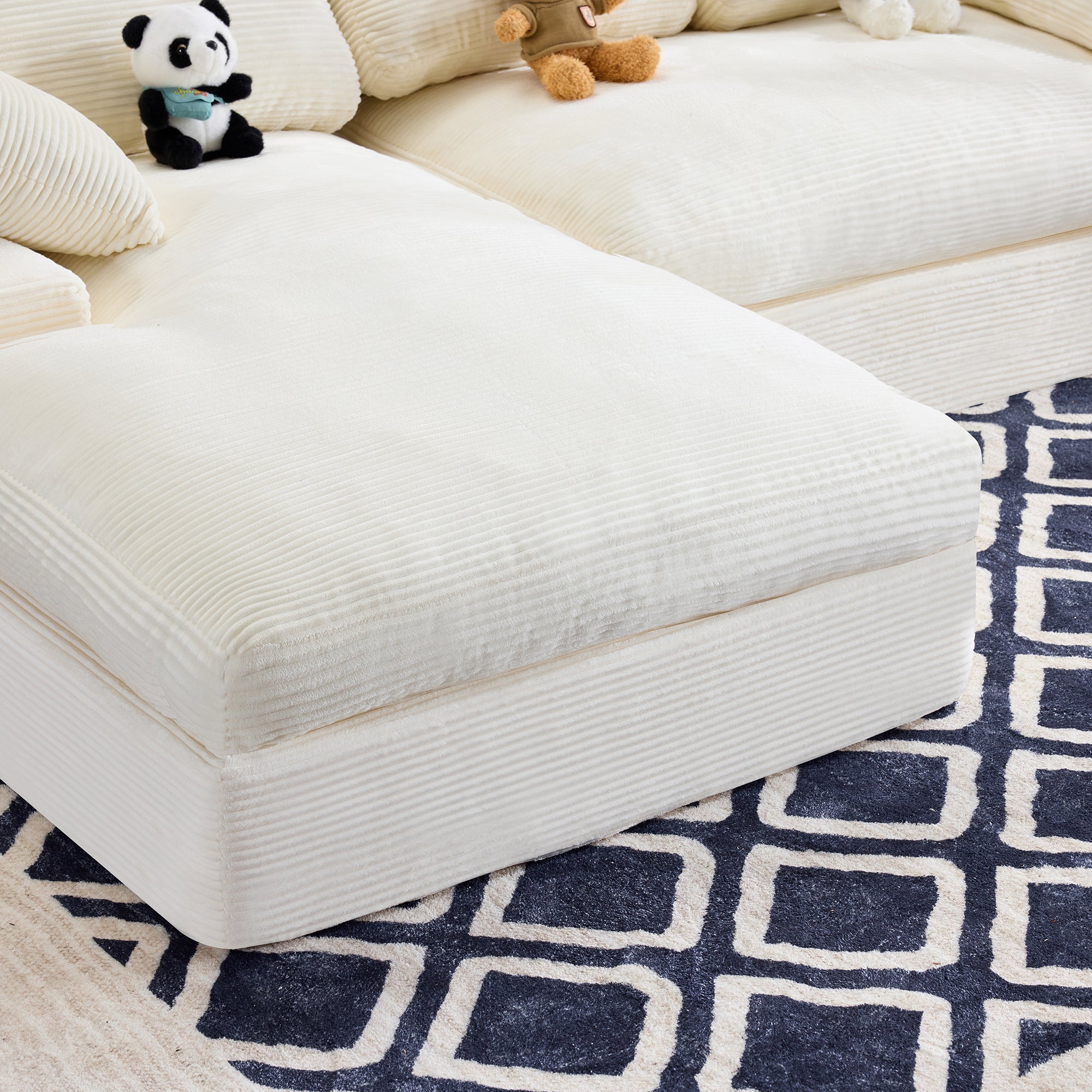 Close-up of chaise section of White Corduroy Sofa with soft ribbed texture and plush cushioning on a navy patterned rug.