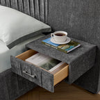 Open drawer of built-in bedside table on queen upholstered bed. Includes books and cup, showcasing functional storage and solid frame.