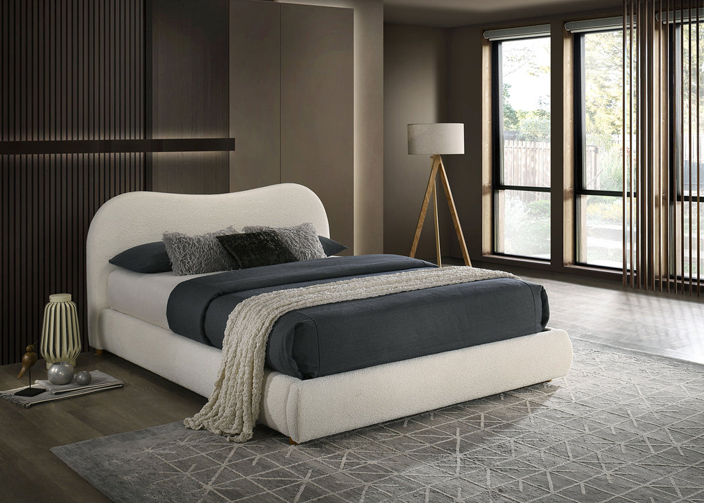 Velvet King Size Bed featuring a curved headboard and plush bedding, set in a contemporary bedroom with floor-to-ceiling windows.
