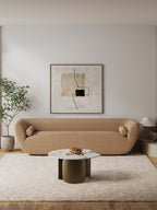 Modern Stone Coffee Table in Bronze placed in a minimalist living room, enhancing decor with its sleek round design and neutral tones.