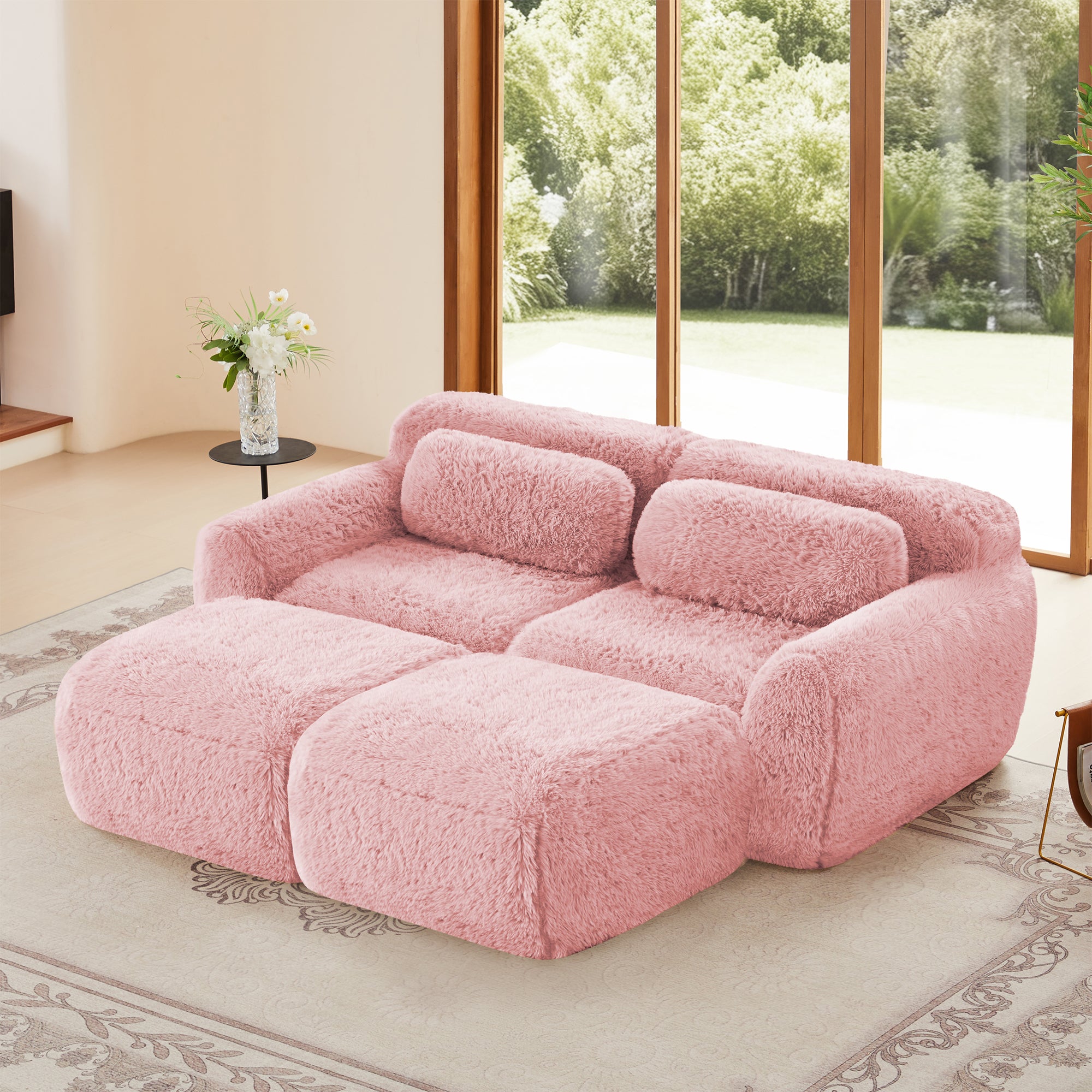 Pink modular plush sofa with ottoman in a sunlit living room, featuring a non-slip base and no assembly design for cozy, modern interiors.