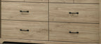 Lower drawers of Elara Light Oak Dresser featuring black metal handles and natural oak wood grain texture.