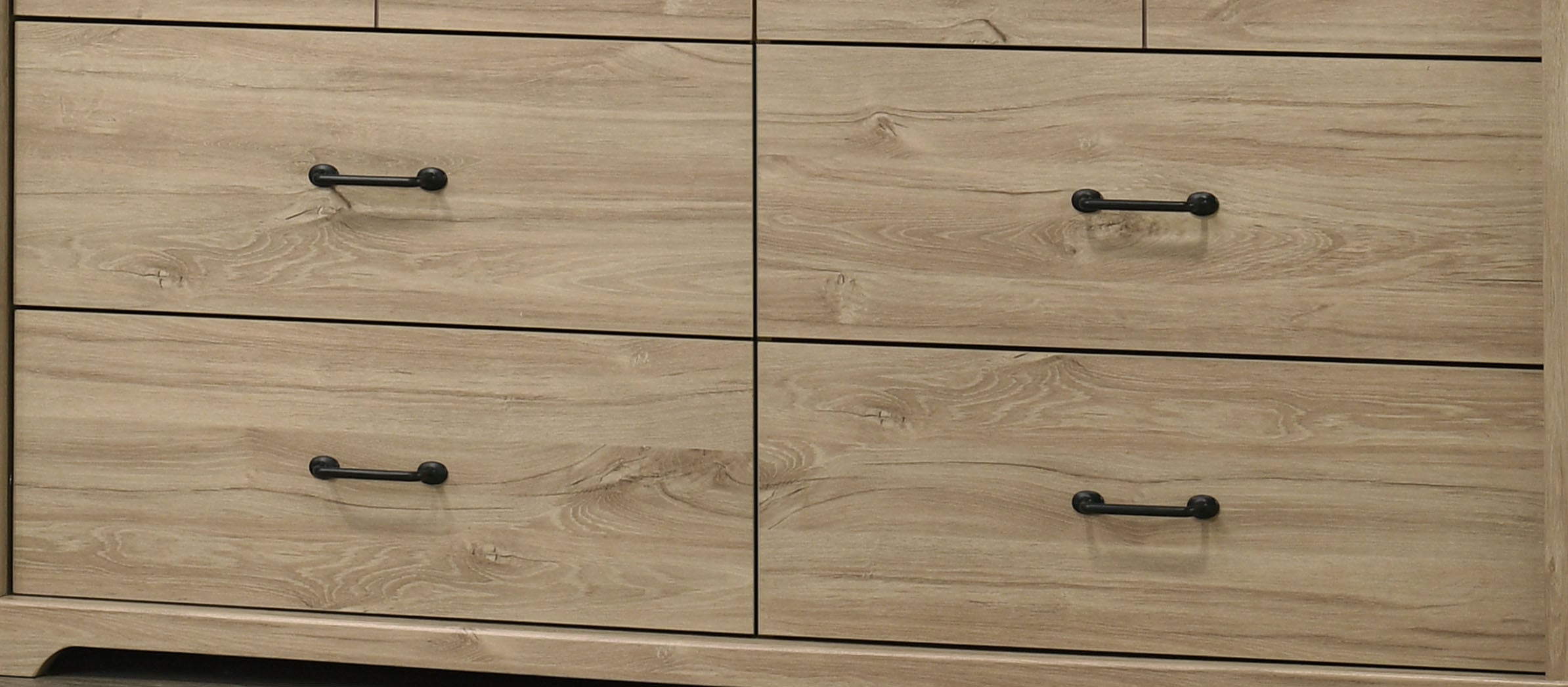 Lower drawers of Elara Light Oak Dresser featuring black metal handles and natural oak wood grain texture.