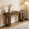 Rustic dark wood console table with a minimalist frame design, styled with a vase, candle, and open book.