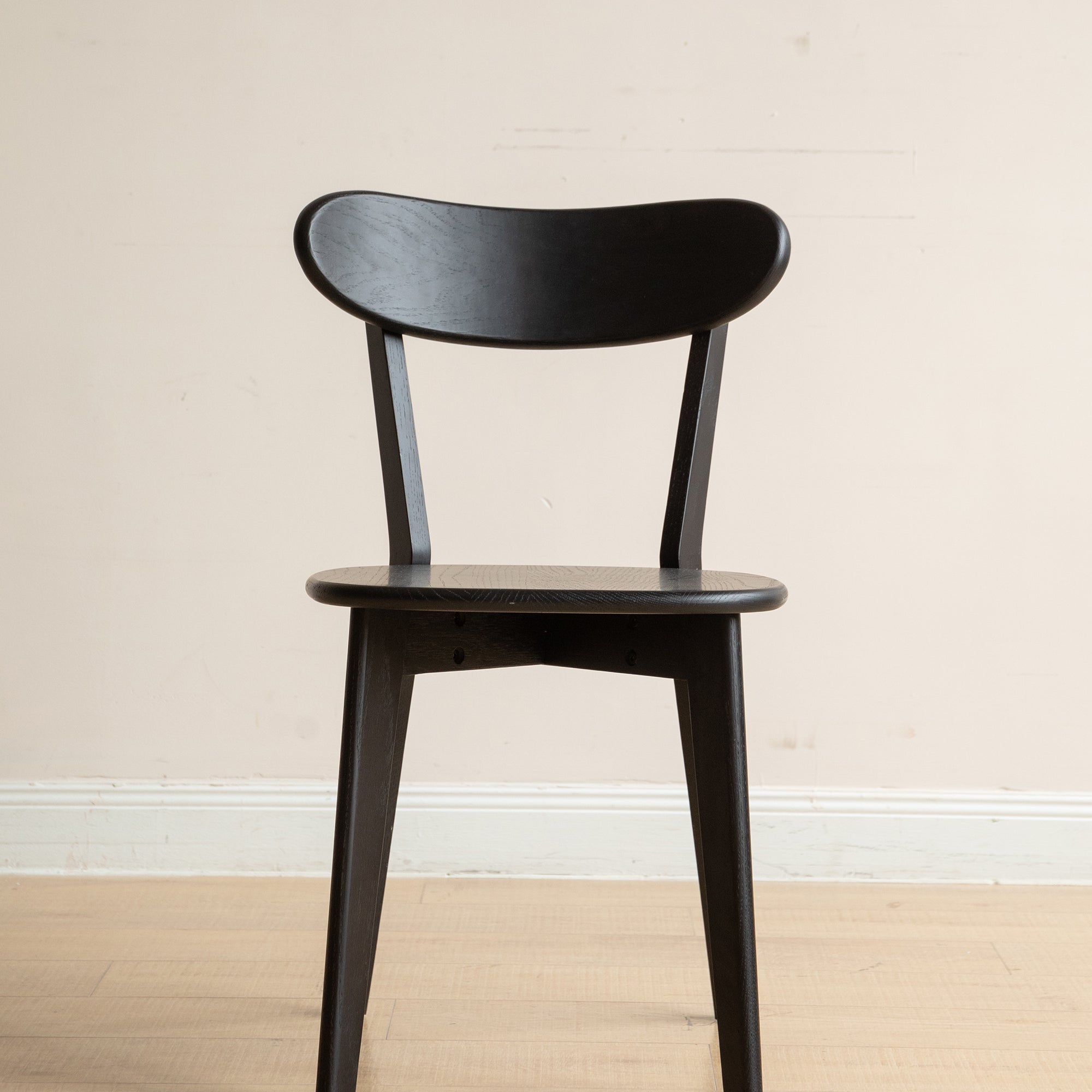 Front view of Solid Oak Dining Chair in black, featuring a contoured seat and supportive backrest for dining comfort.