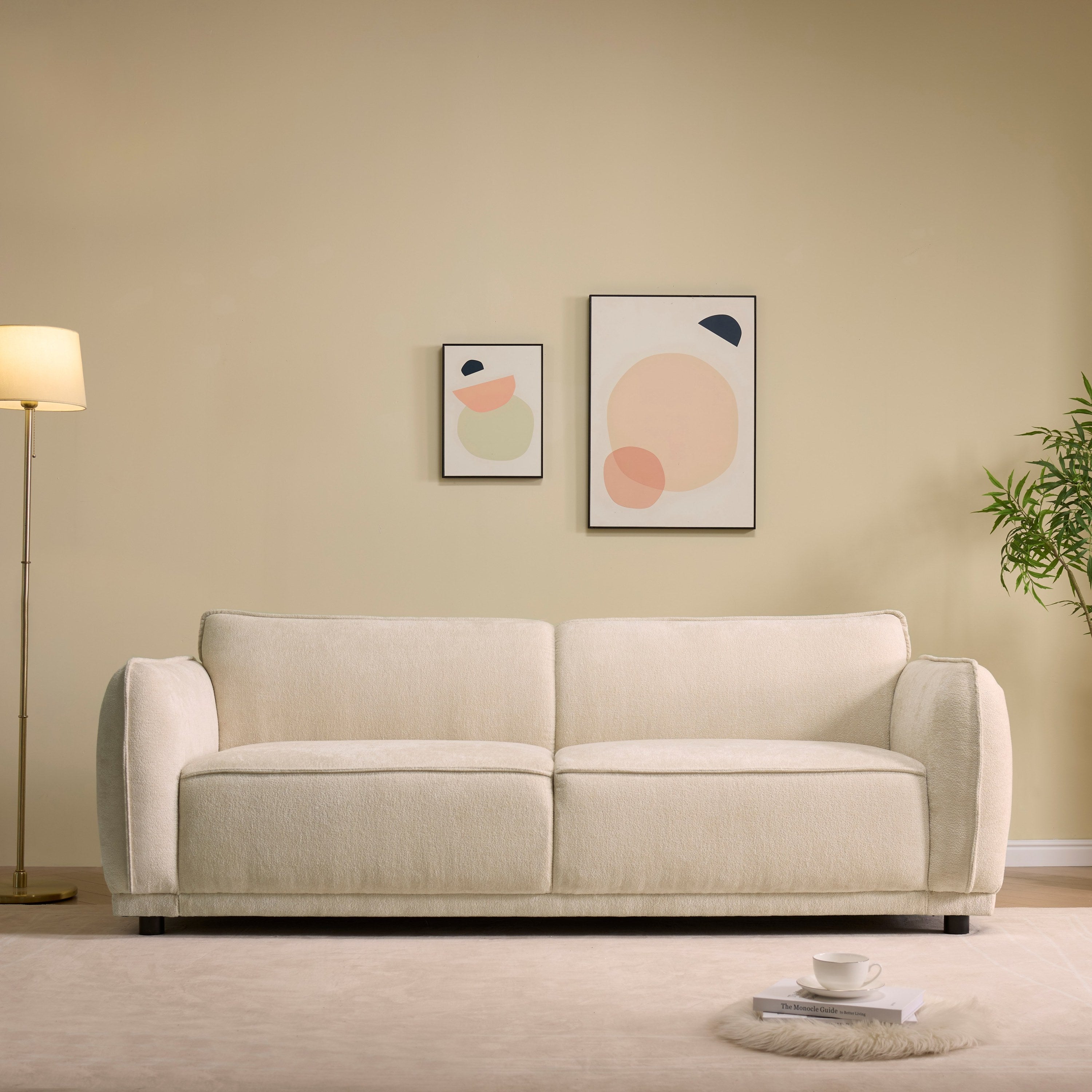 Oslo 84' Round Arm 3 Seater Modern Upholstered Boucle Sofa in beige placed in a stylish living room with minimalist decor and soft lighting.