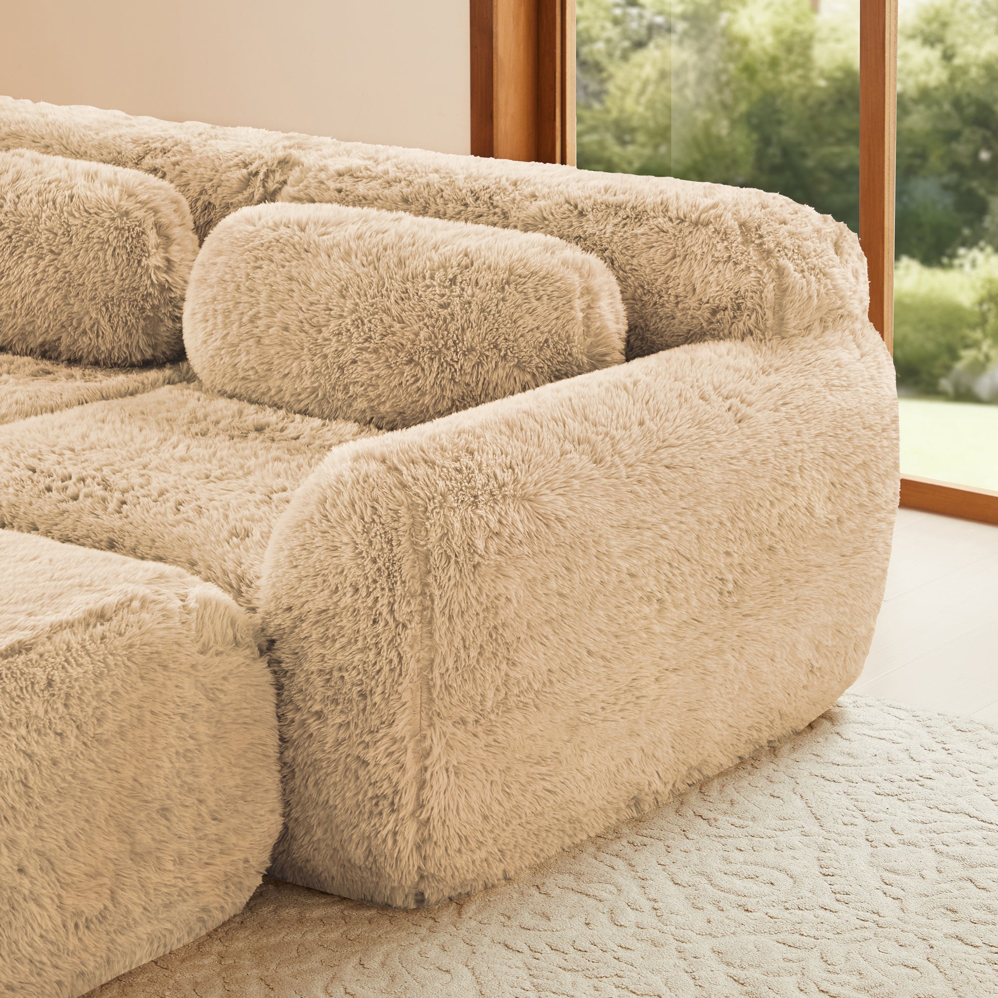 Right side close-up of plush fabric modular sectional sofa. Rounded armrest and backrest for ergonomic support.