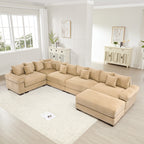 Oversized camel corduroy modular sectional sofa with extra-wide armrests and matching ottoman in a bright living room.