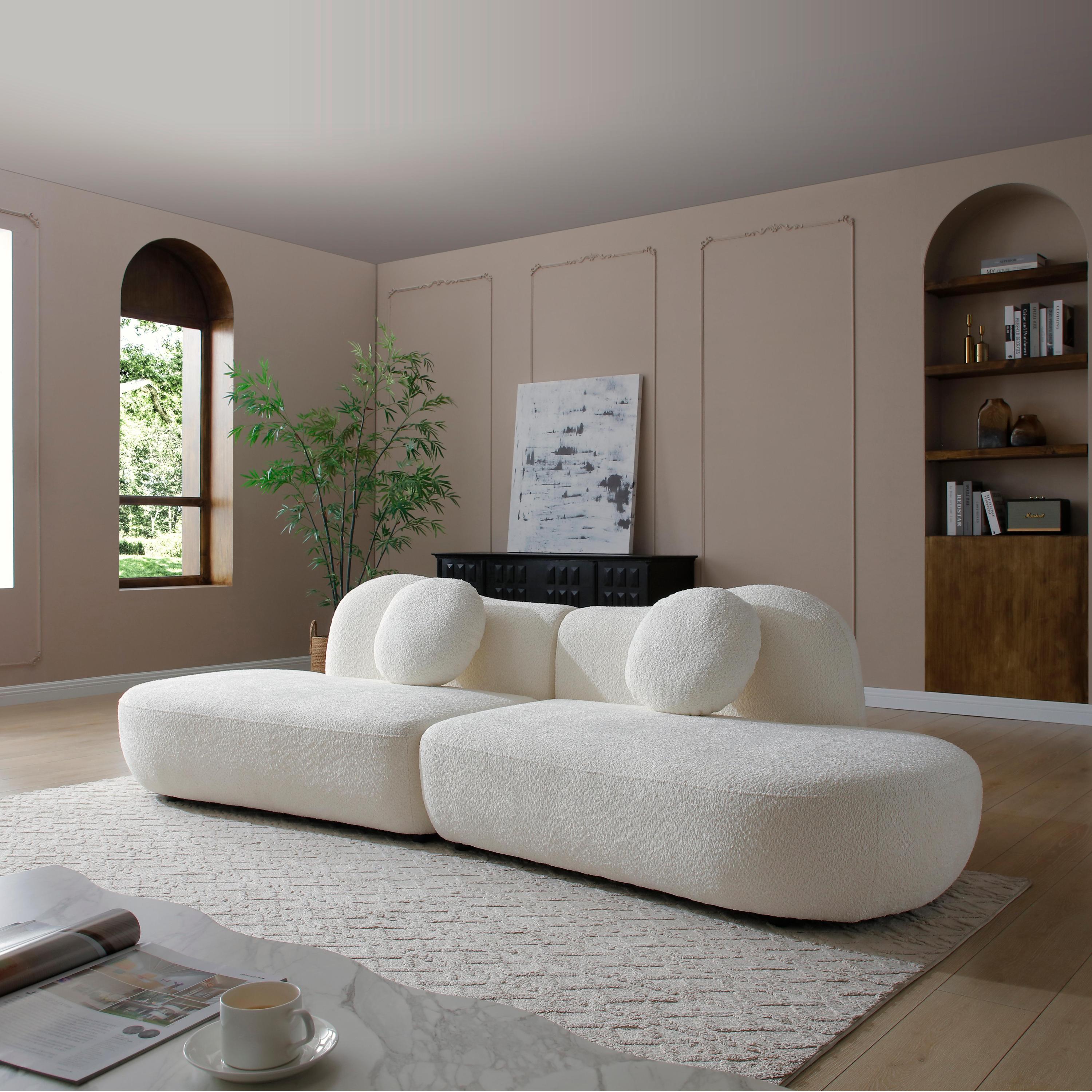 Curved modular sofa in boucle fabric placed in a modern living space, ideal for bedrooms or lounges with artistic decor elements.