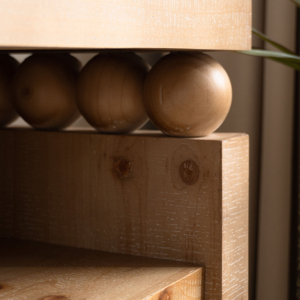 Decorative bead detail on rustic console table, highlighting the natural wood finish and farmhouse-inspired design.
