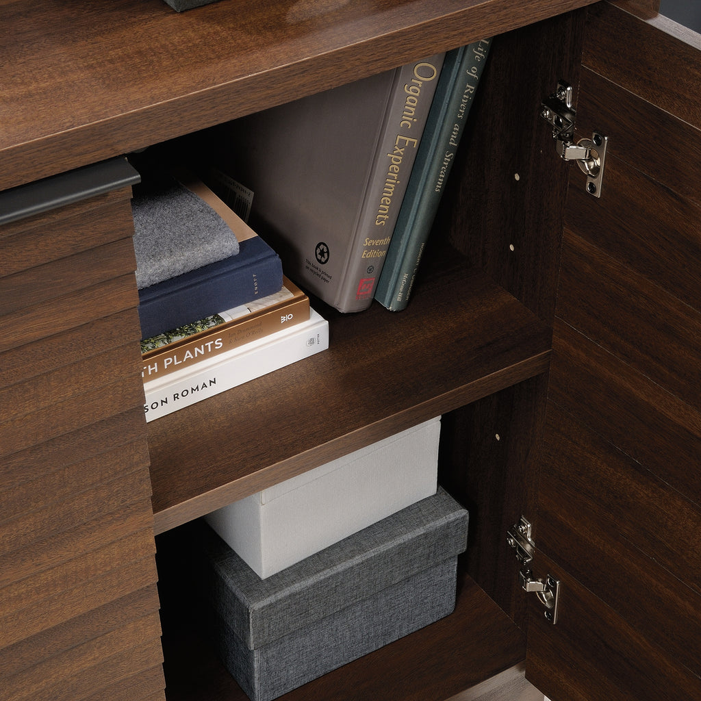 Interior view of Library Base, Brown finish showing adjustable shelves storing books and boxes, perfect for office use.