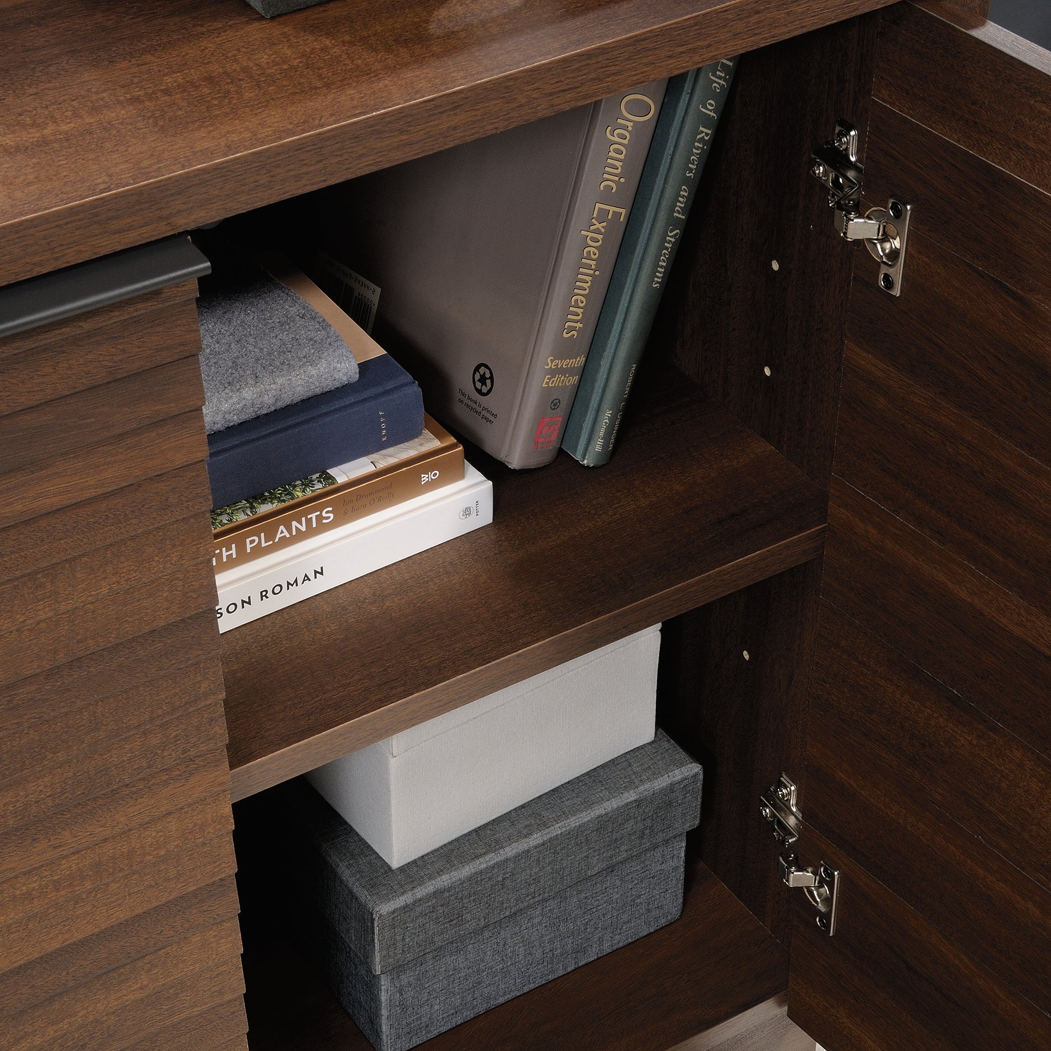Interior view of Library Base, Brown finish showing adjustable shelves storing books and boxes, perfect for office use.